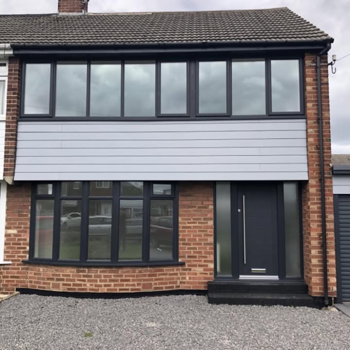 Semi-detached house fitted with anthracite grey windows, cladding panel and a matching front door