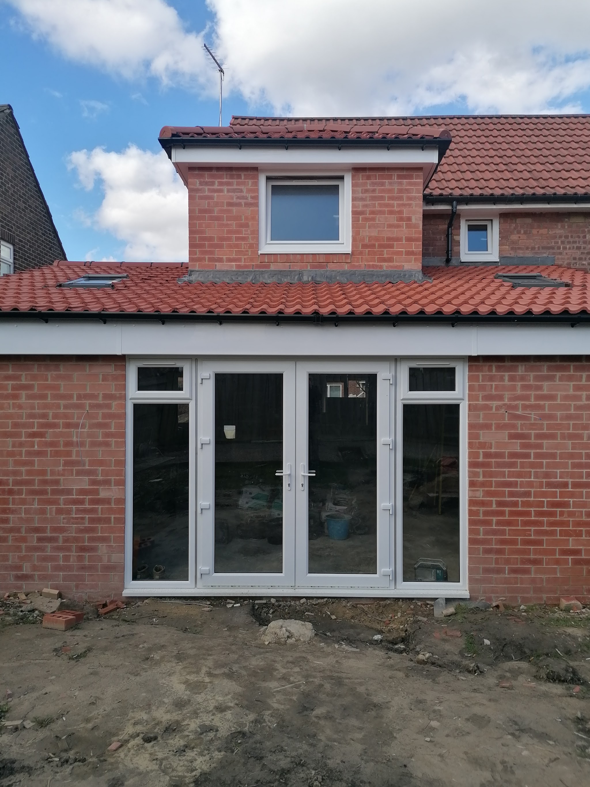 White uPVC French doors with side panels on a new brick extension