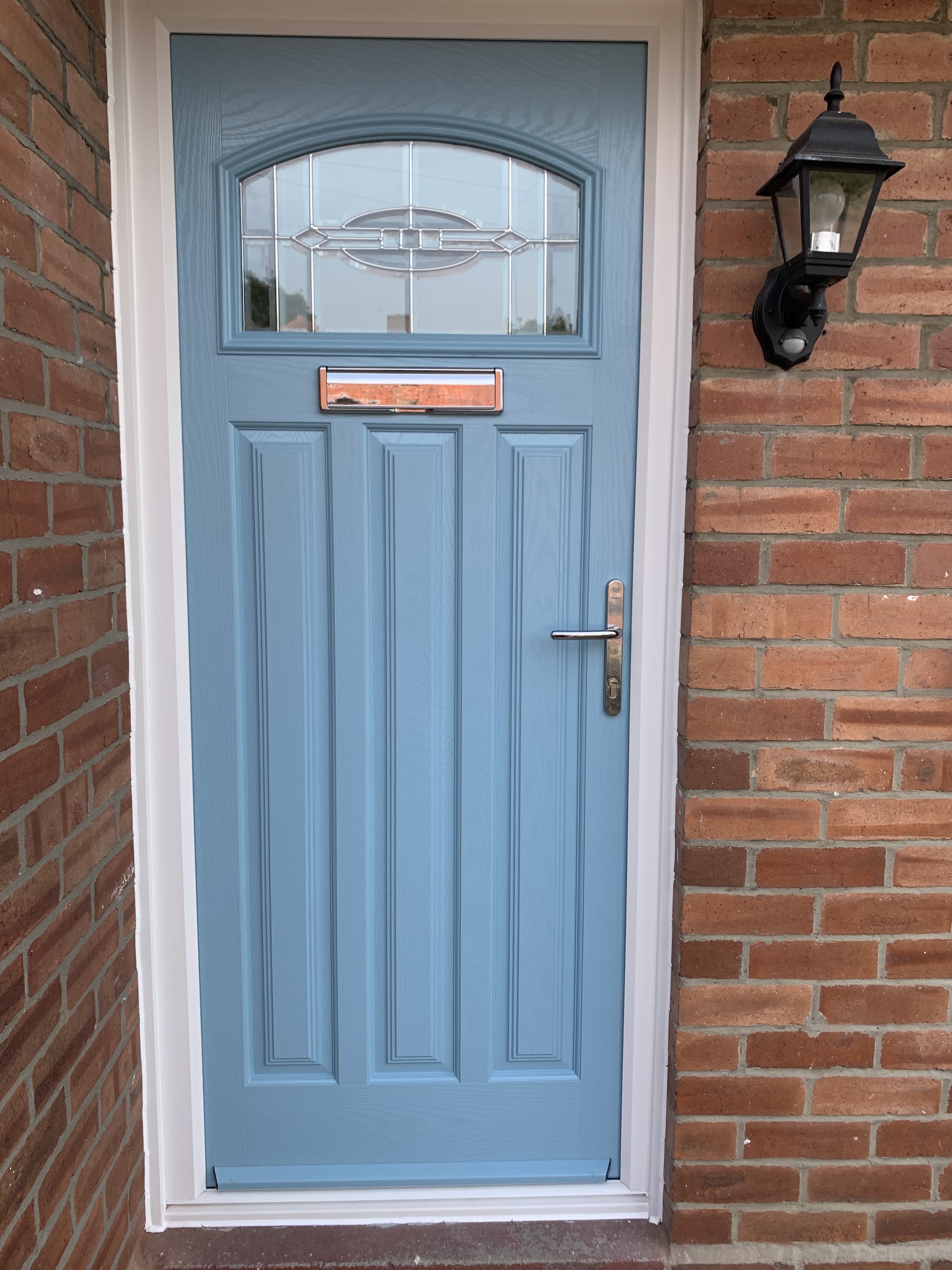 Duck-egg blue composite front door with arched bevelled glass