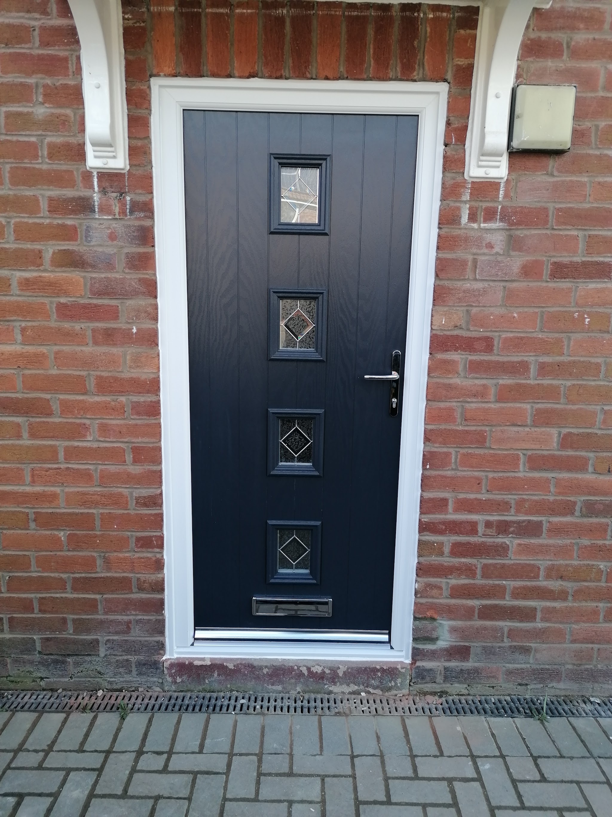 Anthracite composite door with four diamond glass panels set in red brick